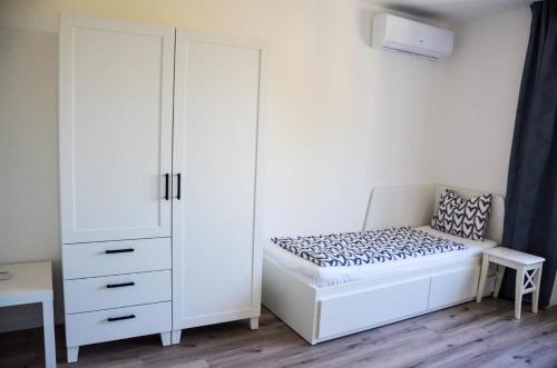 a bedroom with a bed and a white cabinet at Apartmán u Vítka in Mikulov