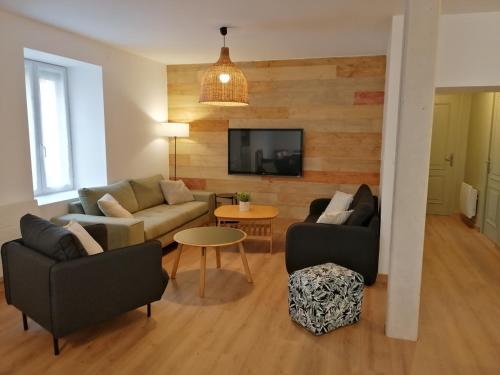 a living room with two couches and a tv at Les Briquettes in Mailly-Champagne