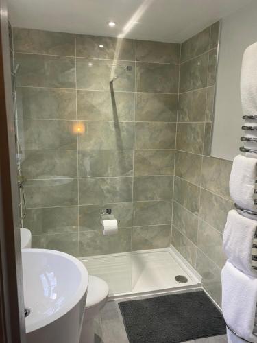 uma casa de banho com um chuveiro, um WC e um lavatório. em Arden House NEC Birmingham em Bickenhill