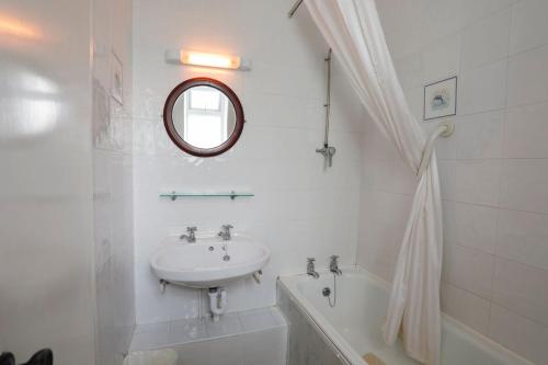 a white bathroom with a sink and a mirror at Atlantic Apartotel in Bundoran