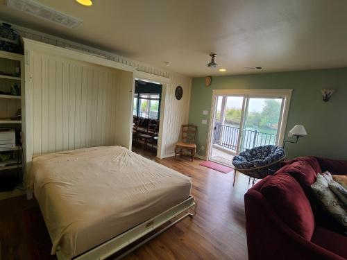 1 dormitorio con 1 cama y 1 sofá en Year-round fishing, boating, birding, 1 hr from SF en Walnut Grove