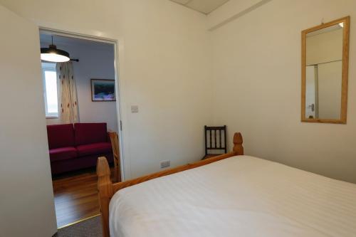 a bedroom with a bed and a red couch at Atlantic Apartotel in Bundoran