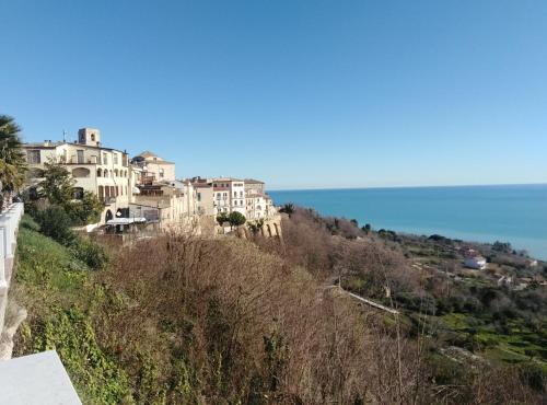 a group of houses on a hill next to the ocean at La casetta sotto l'albero LA CAROVANA GITANA in Vasto