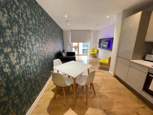 a kitchen and dining room with a table and chairs at Quay Apartments Manchester in Manchester