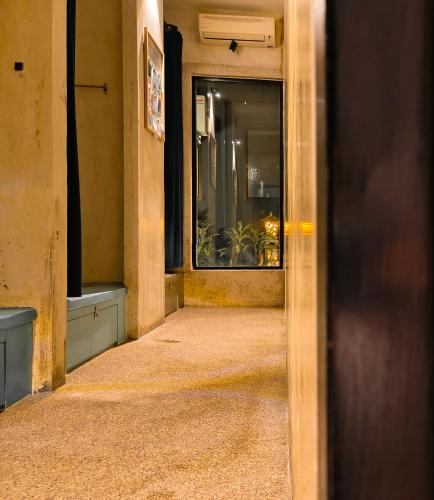 an open door to a hallway with a window at Beds In Garden Hostel in Ipoh