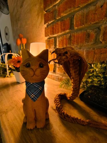 a cat wearing a bow tie sitting on the floor at Beds In Garden Hostel in Ipoh