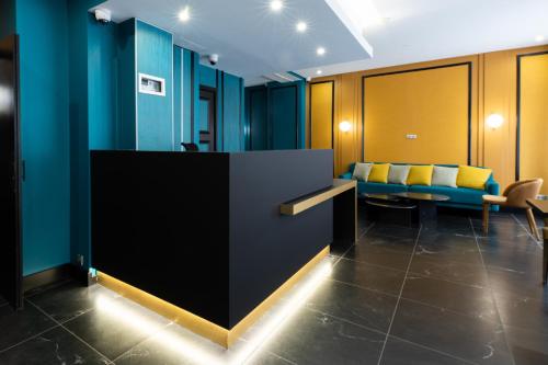 パリにあるオテル ジェランドの青い壁と黄色い椅子が備わる待合室