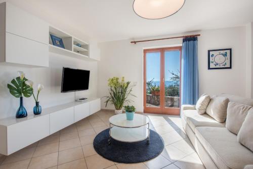 a living room with a couch and a tv at Villa Marianna in Massa Lubrense