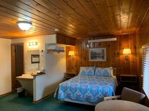 a bedroom with a bed in a room with wooden walls at Meadow Park on 385 in Bridgeport