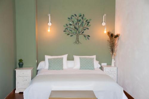a bedroom with a large white bed with two night stands at La Maison des Tilleuls in Saint-Germain-sur-Sèves