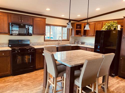 a kitchen with a table with chairs and a black refrigerator at Swan Lake Resort in Galloway