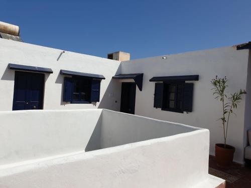 エッサウィラにあるRiad Sidi Magdoulの白い建物(黒窓、鉢植え)