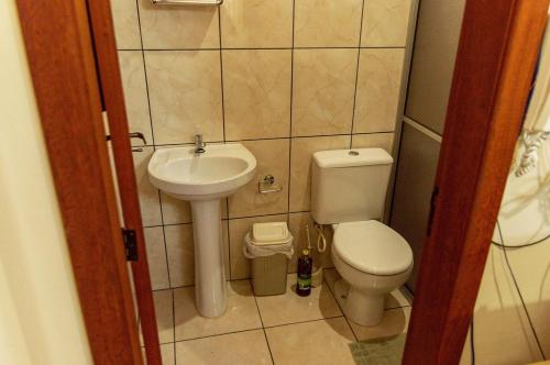 a small bathroom with a toilet and a sink at Chale c piscina e churrasqueira em Sao Leopoldo-RS in São Leopoldo