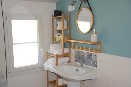a bathroom with a sink and a mirror at La Maison des Tilleuls in Saint-Germain-sur-Sèves