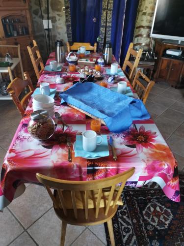 una mesa larga con un mantel colorido encima en Ferme de la Combe, en Saint-Jeure-dʼAy