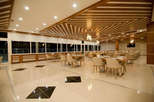 un ristorante con tavoli, sedie e finestre di Mus Grand Hotel a Muş