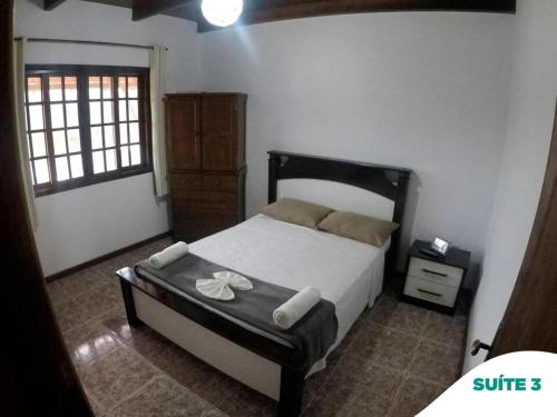 a bedroom with a bed in a room with a window at Suítes do Pontal in Arraial do Cabo