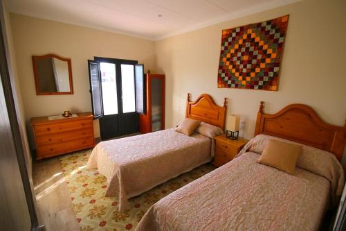 a bedroom with two beds and a painting on the wall at Casa TAPIOLAS in Borrassá