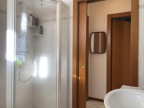La salle de bains est pourvue d'une douche en verre et d'un lavabo. dans l'établissement 012 Trilocale, Carisolo, à Carisolo