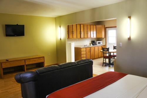 a living room with a couch and a kitchen at La Huerta Inn & Suites in Cuauhtémoc