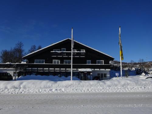 a building covered in snow with a pile of snow at Øen Turistsenter Apartments in Geilo