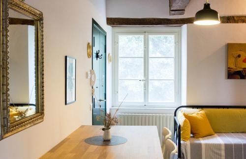 uma sala de estar com uma mesa e um sofá amarelo em La finestra sul parco em Lucca