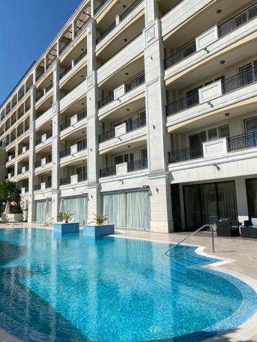 a large swimming pool in front of a building at Private Super apartments by sea in Apart Hotel ! in Pomorie