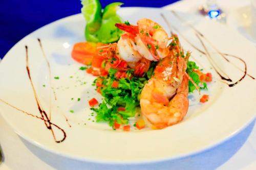 a plate of food with shrimp and vegetables on a table at Hôtel Ivotel Abidjan in Abidjan