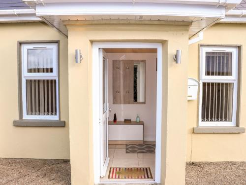 a door to a bathroom in a yellow house at Lane Cottage 