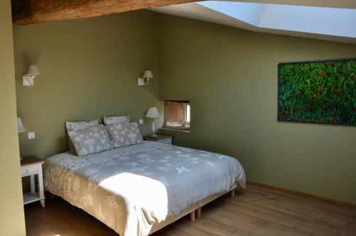une chambre avec un lit et un tableau au mur dans l'établissement CLOS SAINT SAUVEUR - guesthouse au coeur des vignes sur le coteau, à Saint-Pierre-dʼAurillac