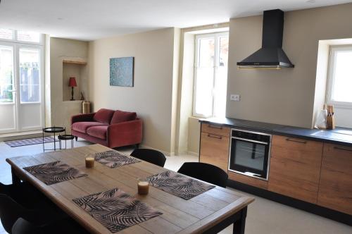 sala de estar con mesa y cocina en CLOS SAINT SAUVEUR - guesthouse au coeur des vignes sur le coteau, en Saint-Pierre-dʼAurillac