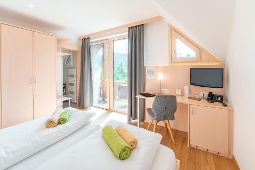 a bedroom with a bed and a desk with a computer at Stampferhof in Weissensee