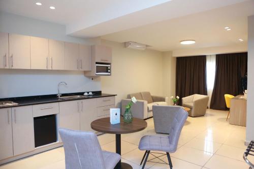 a kitchen and living room with a table and chairs at Hôtel Ivotel Abidjan in Abidjan