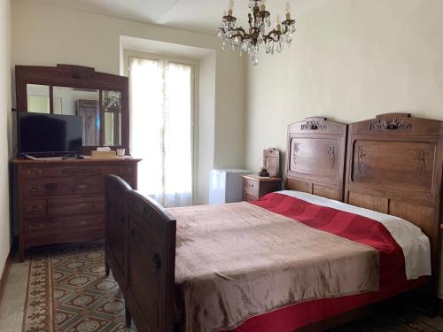 a bedroom with a bed and a television and a chandelier at Coppo 1829 in Portacomaro