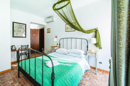 a bedroom with a bed with a green comforter at La Fabbrica dell'Oro in Asti