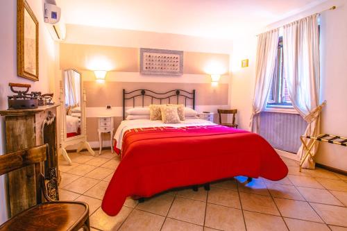 a bedroom with a large bed with a red blanket at La Fabbrica dell'Oro in Asti