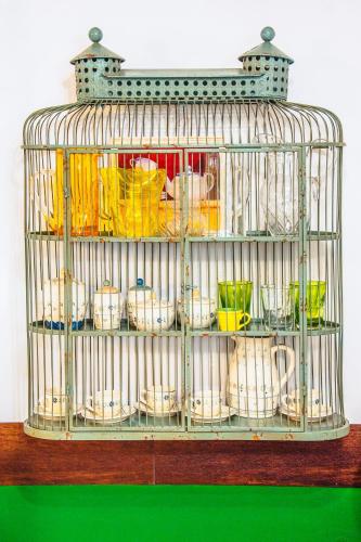 a bird cage filled with different colored dishes at La Fabbrica dell'Oro in Asti