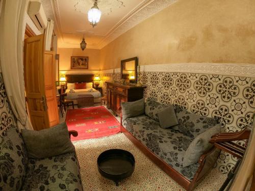 a living room with a couch and a bed at Riad Inaka in Marrakech