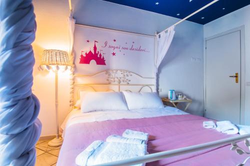 a bedroom with a pink bed with a castle on the wall at La Fabbrica dell'Oro in Asti