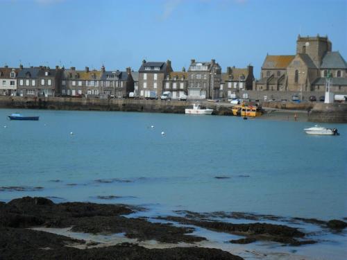 een grote hoeveelheid water met gebouwen en boten bij Maison centre de Barfleur in Barfleur
