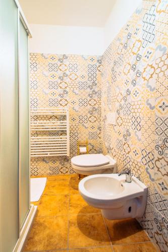 a bathroom with two toilets and a sink at La Fabbrica dell'Oro in Asti