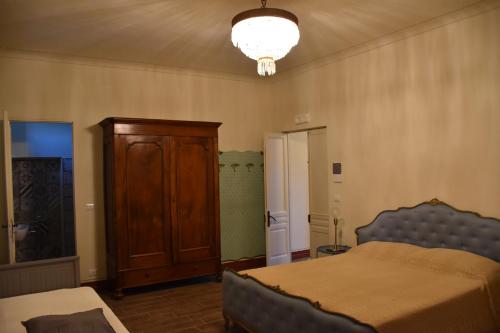 a bedroom with a bed and a chair and a chandelier at Coppo 1829 in Portacomaro