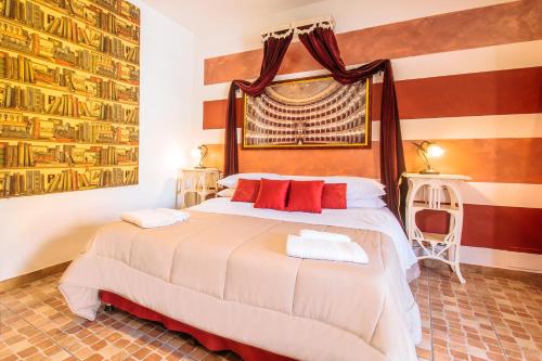 a bedroom with a large bed with red pillows at La Fabbrica dell'Oro in Asti