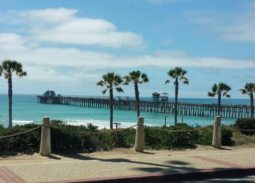 a beach with palm trees and a pier at Castlegate Guest Apartment in Vista