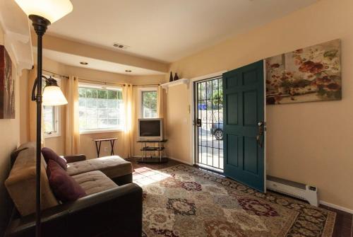 a living room with a couch and a tv and a door at Castlegate Guest Apartment in Vista