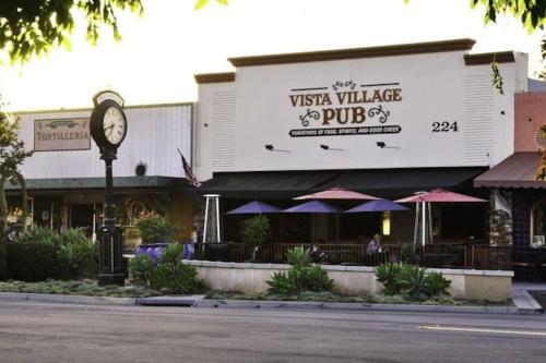 a restaurant with a clock in front of a building at Castlegate Guest Apartment in Vista