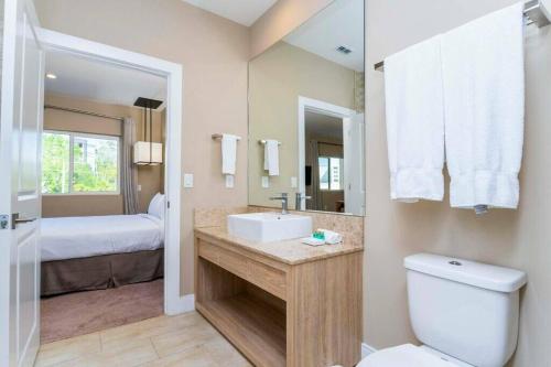 a bathroom with a sink and a toilet and a bed at Beautiful Magic Village 4 Suites near Disney 7493 in Orlando