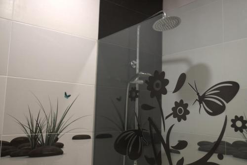 a bathroom with a shower with butterflies and flowers on the wall at CASA ALIS in Arrecife