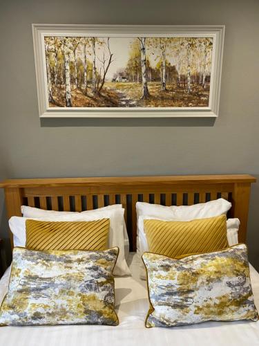 um quadro pendurado por cima de uma cama com duas almofadas em Rufford Arms Hotel em Rufford