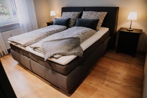 una camera da letto con un grande letto con coperte e cuscini di Waldblick Herborn a Herborn